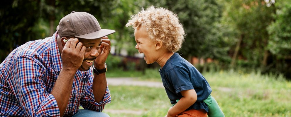 Father and son playing together outside.