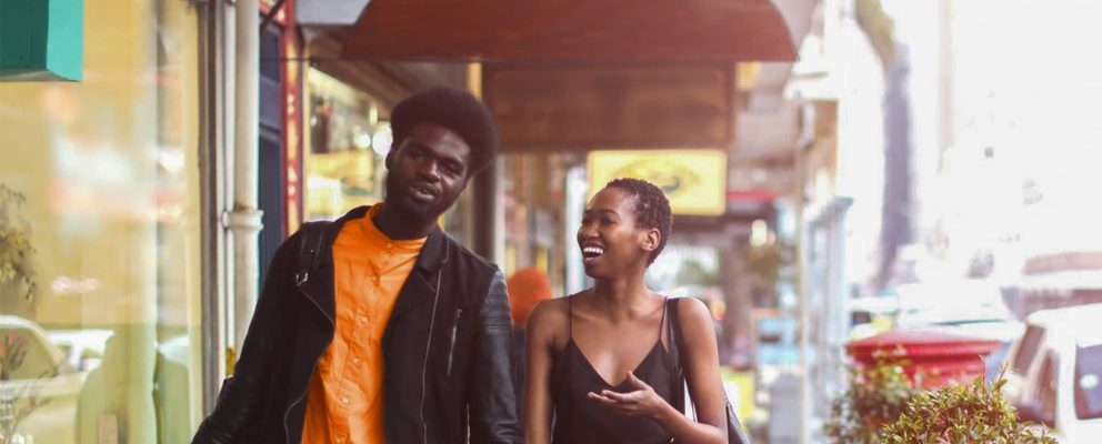 Couple laughing and walking down the street.