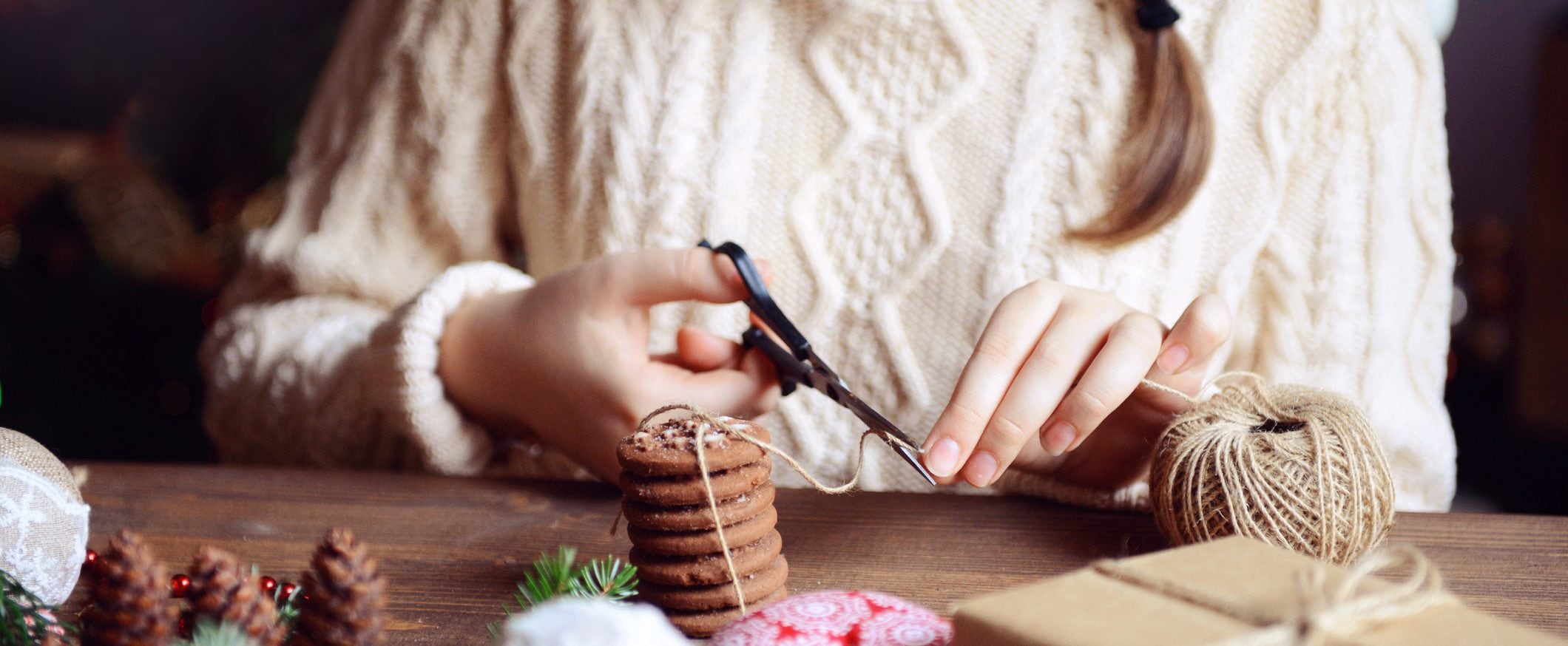 Person carefully cuts twine after packaging cookies for a special occasion.