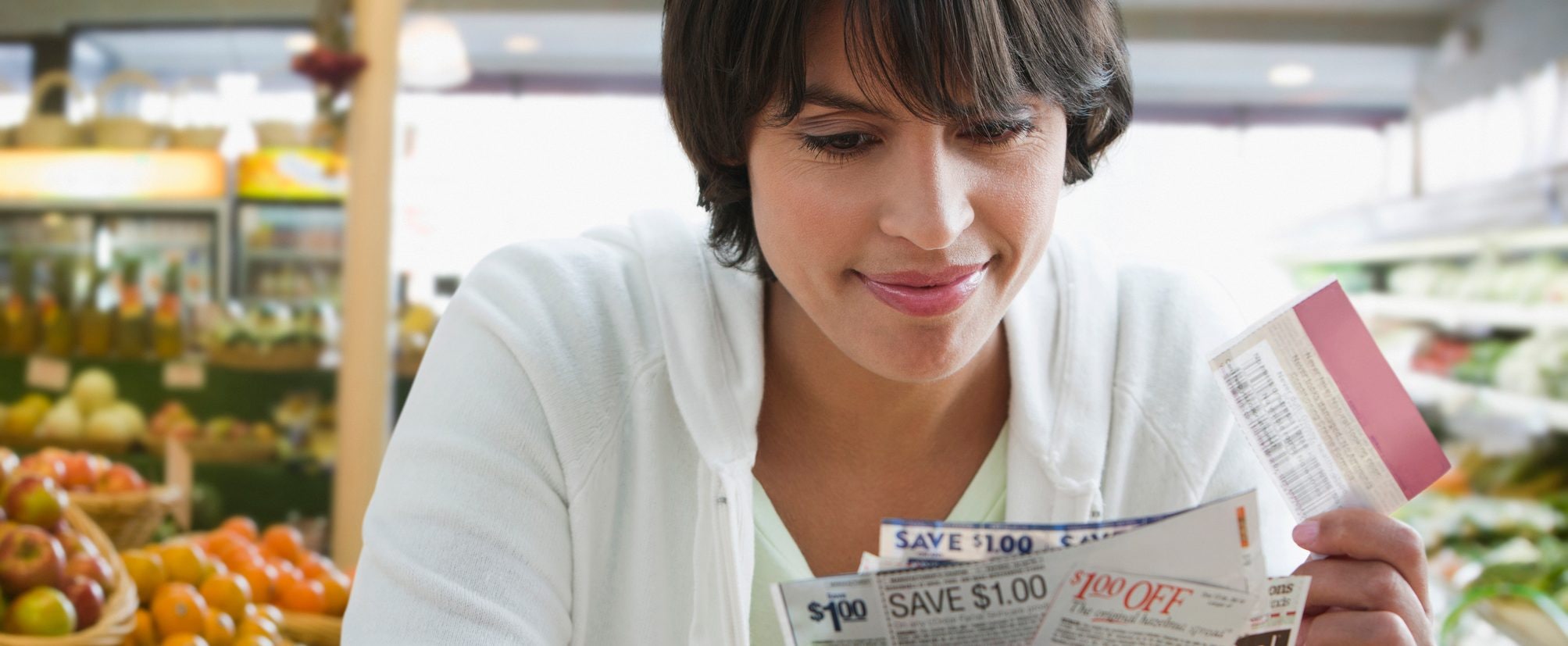 A woman shopping at a grocery store looks through her coupons.