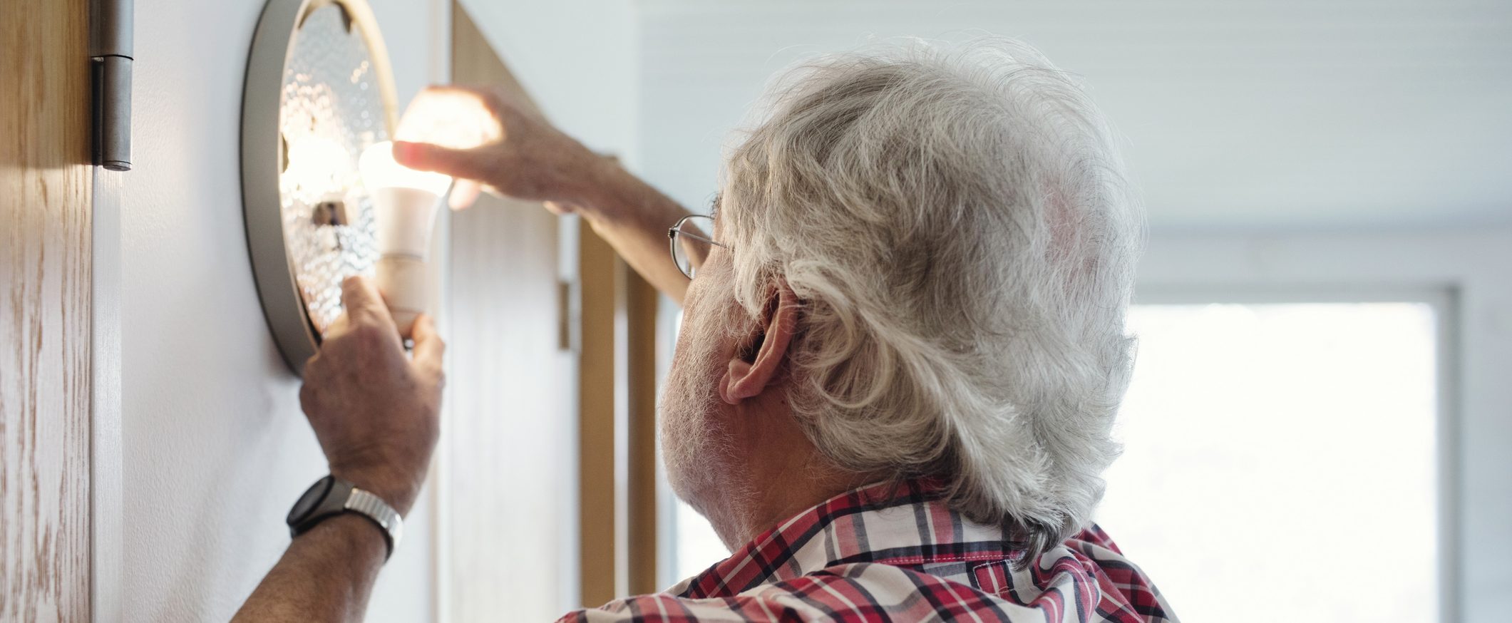 A man changes a lightbulb.