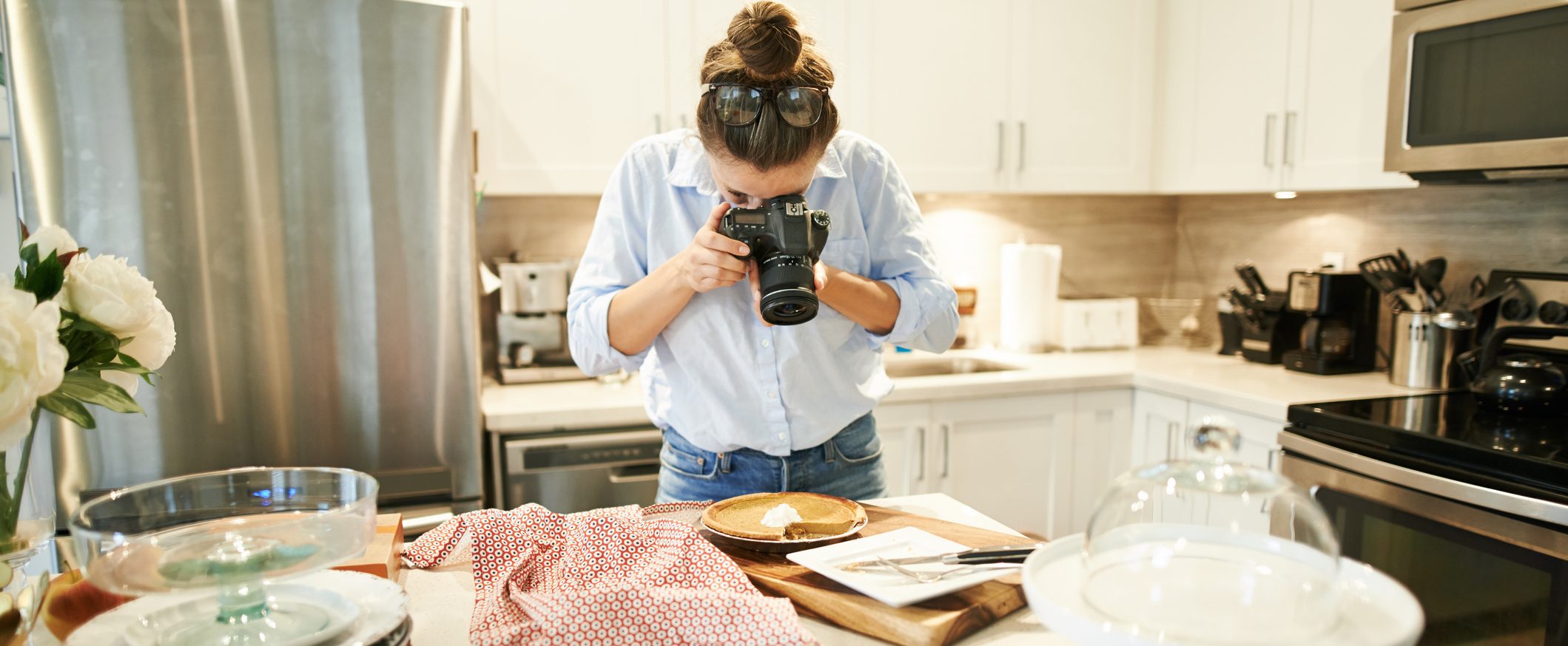 A person takes photos in a kitchen.