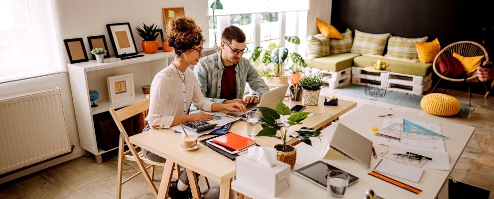 A couple looks at a laptop together.
