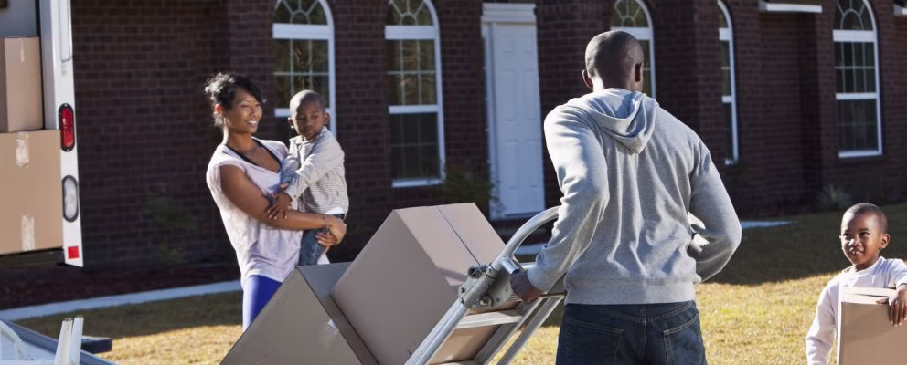 A wife and husband and their two young sons moving out of their house.