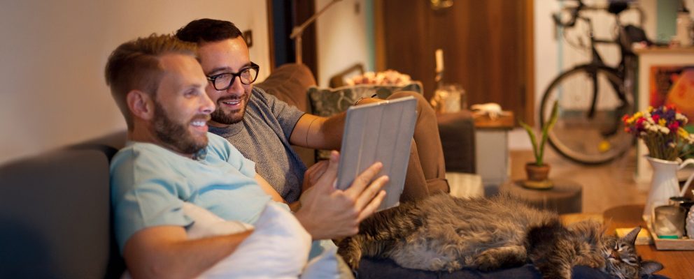 Two men look at a tablet.