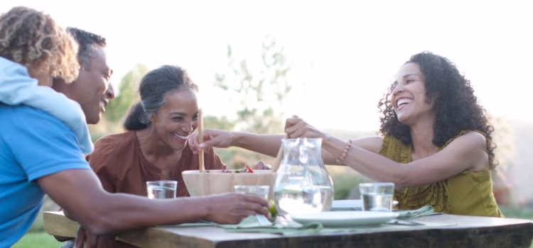 Grandparents share a meal with their daughter and grandchild.