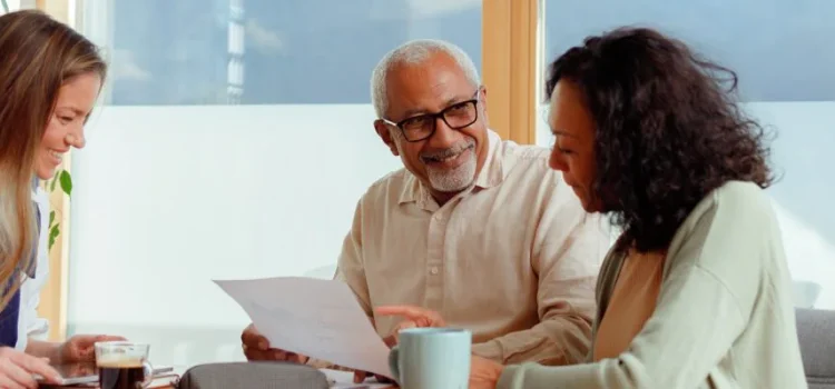 A retired couple meets with an agent to review paperwork.