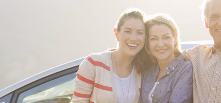 Parents and college-aged daughter smiling for a photograph