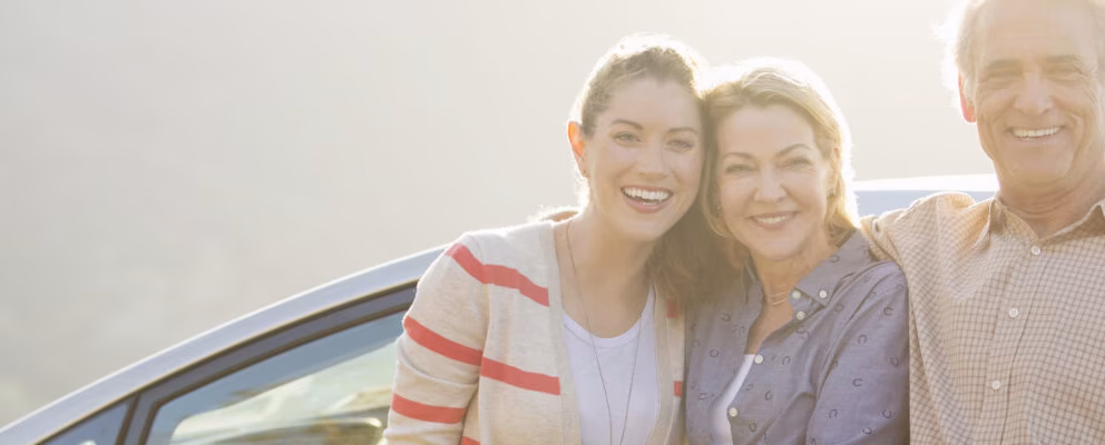Parents and college-aged daughter smiling for a photograph