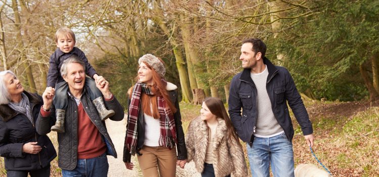 Grandparents walk outside with their grandson and his parents.