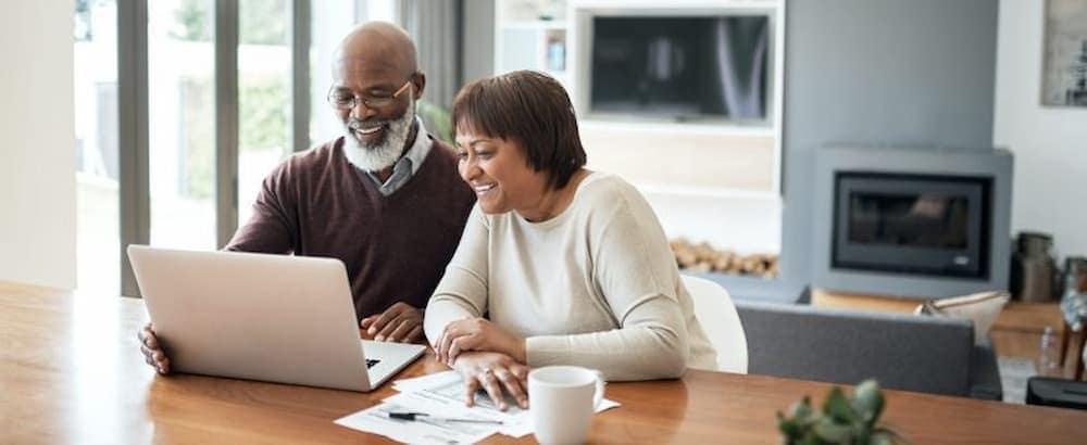 A couple looks at a laptop together.
