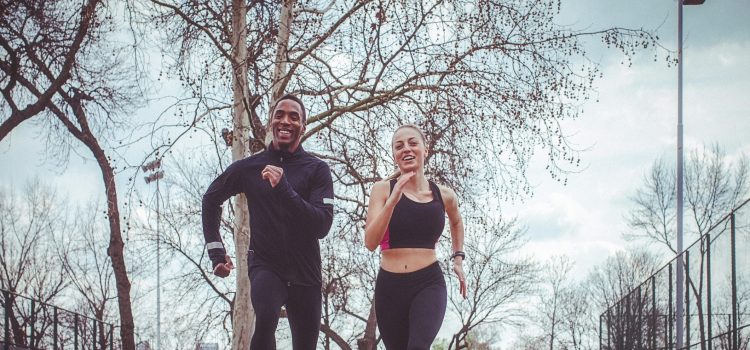 A man and a woman jog outside.