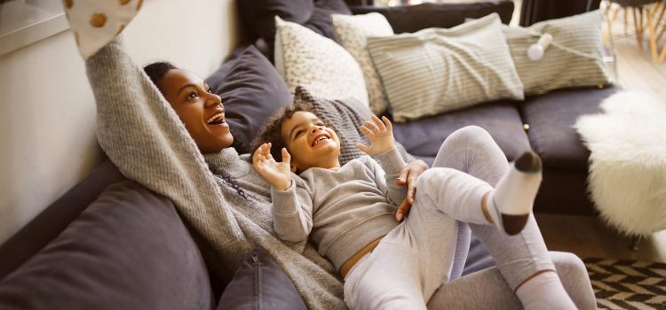 A mother and child play on a couch